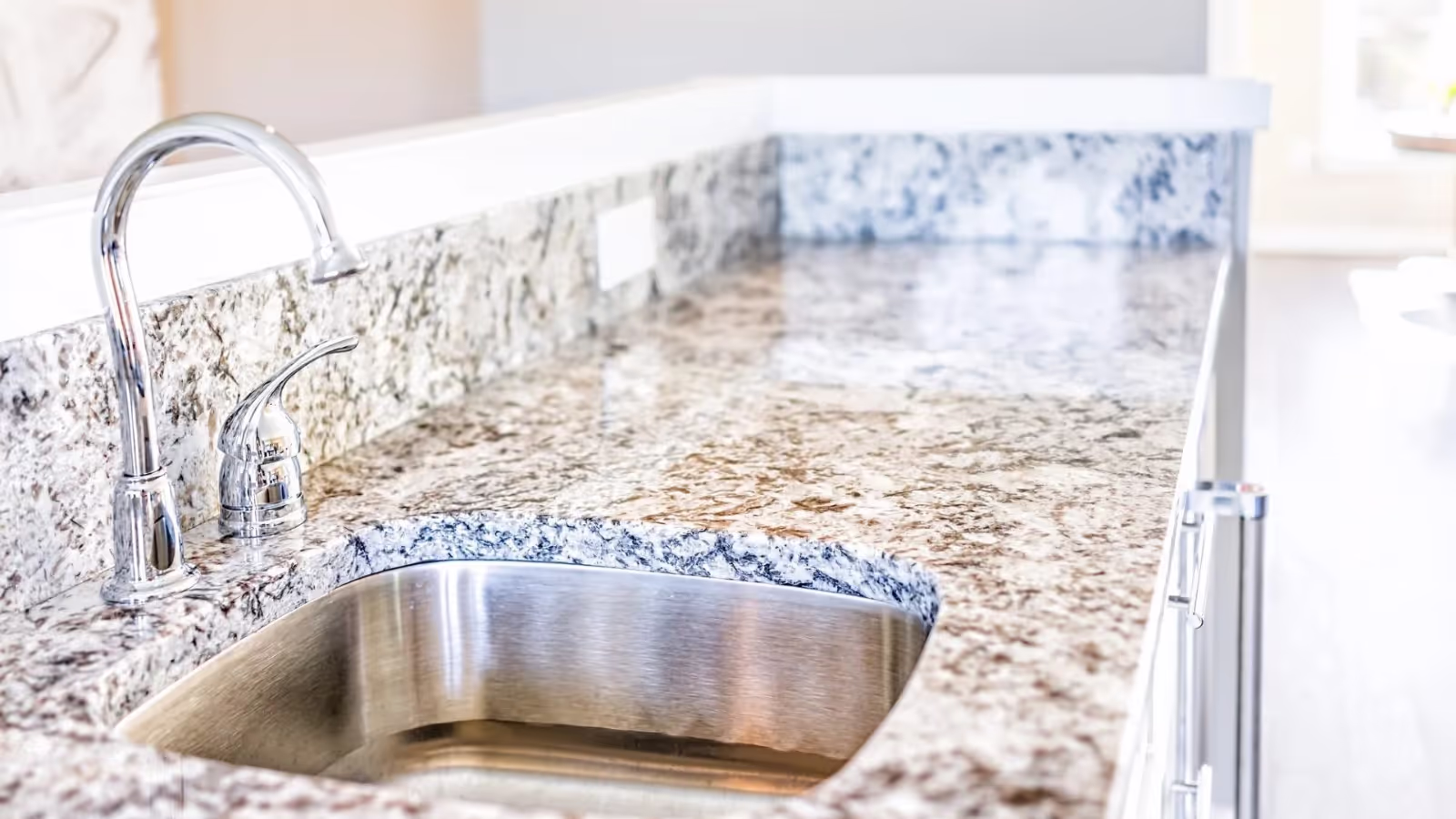 side angle photo of a kitchen granite countertop with undermount sink.